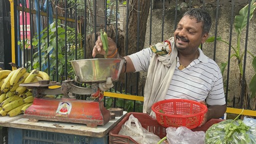 路上で野菜を売る男性